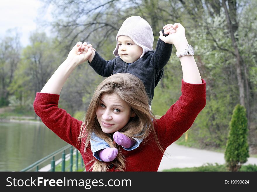 Mother carrying her baby boy on her shoulders. Mother carrying her baby boy on her shoulders