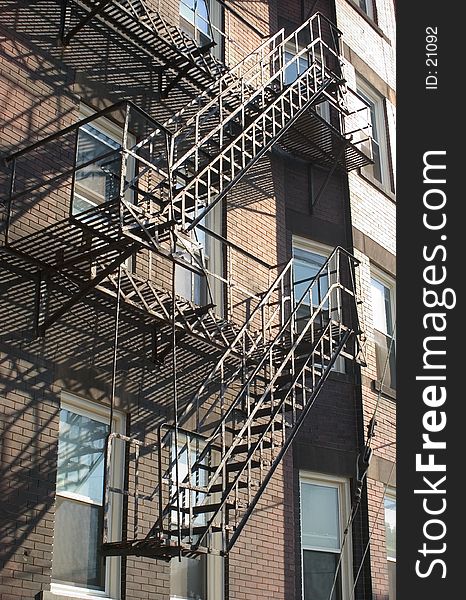 Two stairways form a fire escape on the side of a very old building in NorthEastern Ohio. Two stairways form a fire escape on the side of a very old building in NorthEastern Ohio.