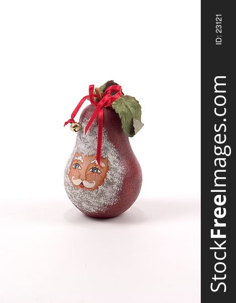 A wooden pear painted with Santa's face and with ribbons, bells and holly leaves attached. A wooden pear painted with Santa's face and with ribbons, bells and holly leaves attached