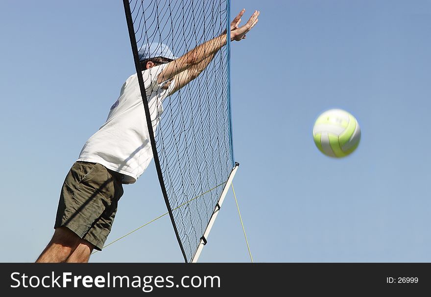 Young man hitting the ball over the net. Young man hitting the ball over the net