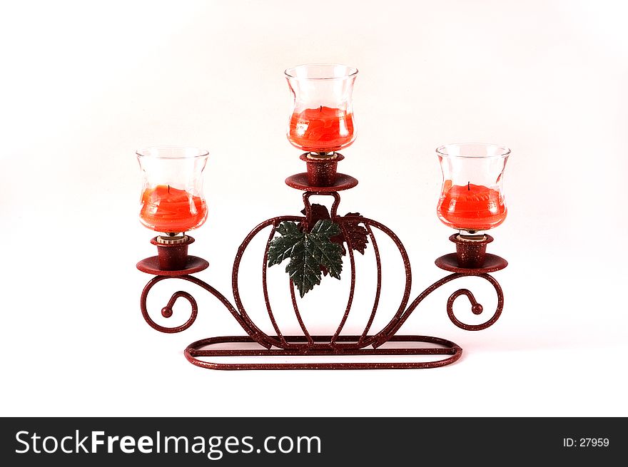 A pumkpin candle holder holds three votive cups and candles as a center piece. A pumkpin candle holder holds three votive cups and candles as a center piece.