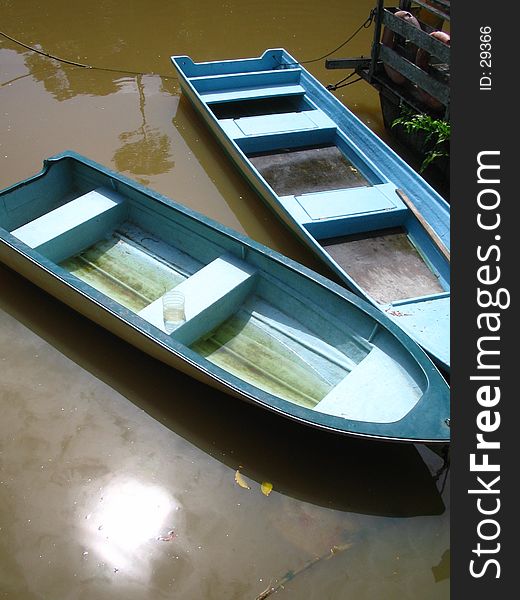 Two bright blue rowboats at a misty river in borneo, sarawak, malaysia. Two bright blue rowboats at a misty river in borneo, sarawak, malaysia