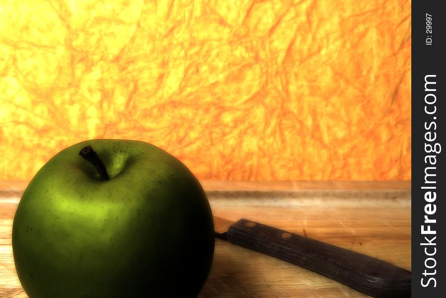 Photo of a Green Apple With Orange Background With Blur and Color Effect.