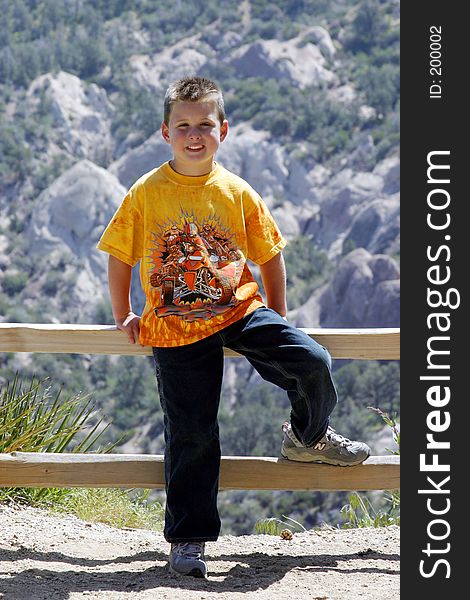 This is an image of a young man, standing by a wooden fence, in the devils punchbowl area, in southern california. This is an image of a young man, standing by a wooden fence, in the devils punchbowl area, in southern california.