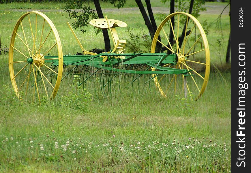 An old green and yellow tractor rake