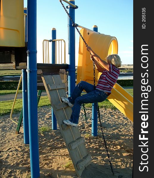 A young girl climbing on playground equipment. A young girl climbing on playground equipment