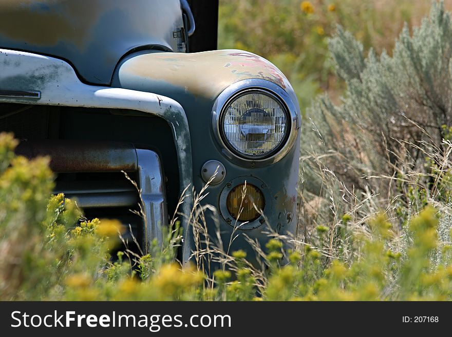Vintage farmtruck abandoned in a field - focus on headlight. Vintage farmtruck abandoned in a field - focus on headlight