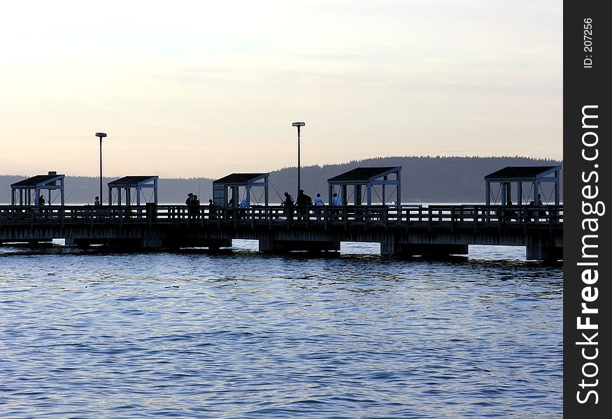 Part of a public fishing pier on the Tacoma Waterfront, silhouetted against an evening sky.