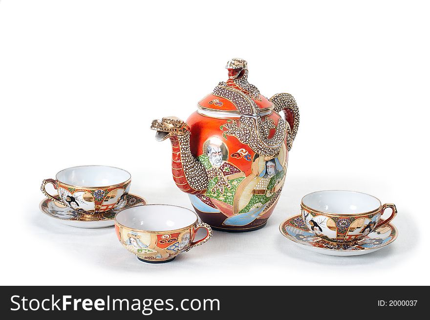 Antique red teapot with dragon and three cups. Antique red teapot with dragon and three cups.