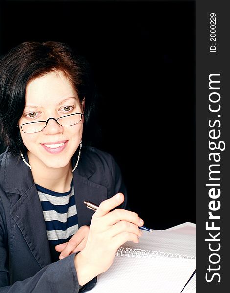 Young woman working, having conversation, note-pad and pen on black background. Young woman working, having conversation, note-pad and pen on black background