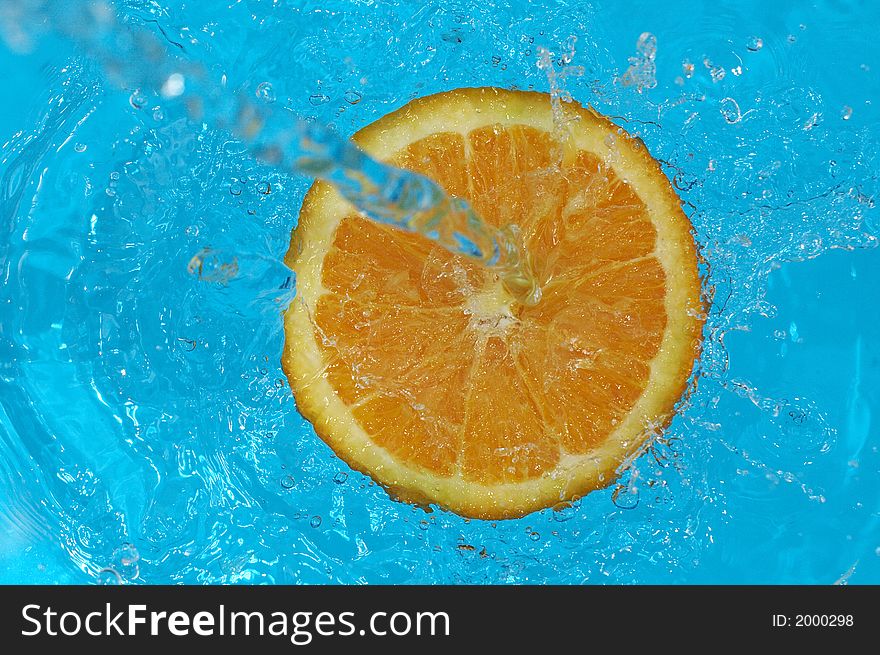 Water splashing on orange in water. Water splashing on orange in water