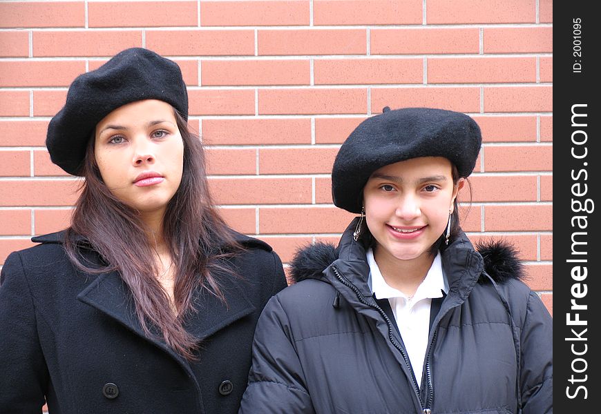 Two happy young girls with beret and coats
