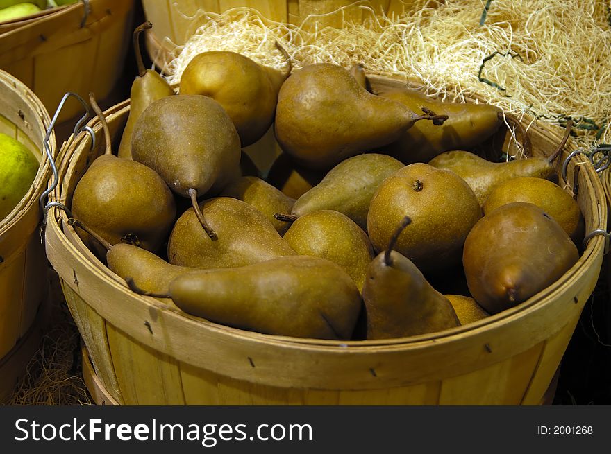 A bunch of pears on a wooden basket for sale. A bunch of pears on a wooden basket for sale