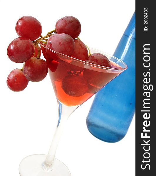 Red wine with grapes and blue bottle over white background
