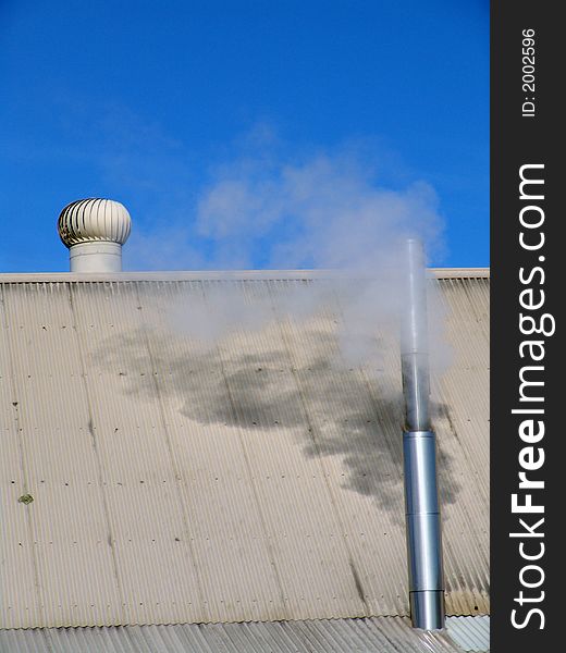 Smoke coming out of the chimney on a roof with an air freshener. Smoke coming out of the chimney on a roof with an air freshener