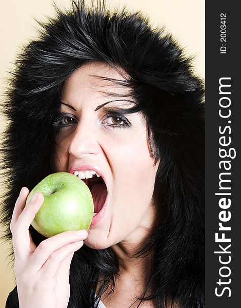 Brunette woman with winter coat and holding a green apple. Brunette woman with winter coat and holding a green apple