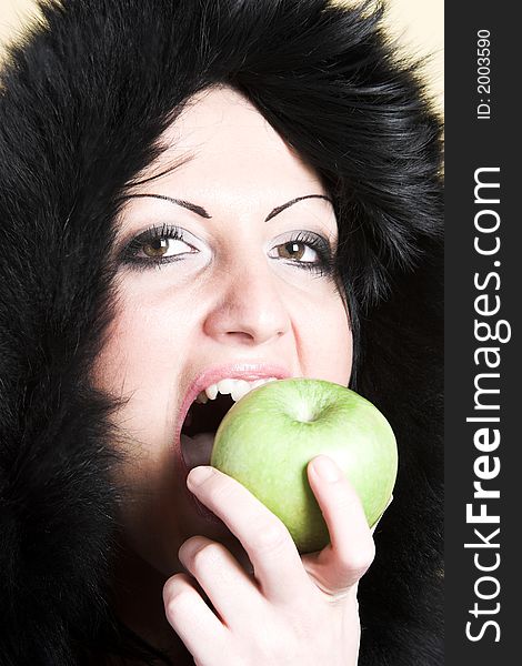 Brunette woman with winter coat and holding a green apple. Brunette woman with winter coat and holding a green apple