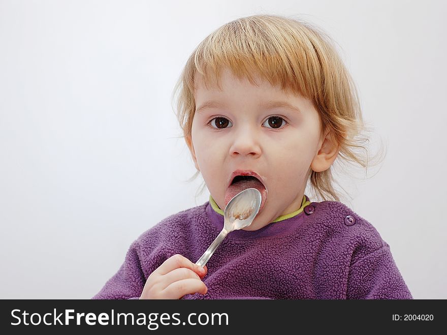 Child licking an empty spoon