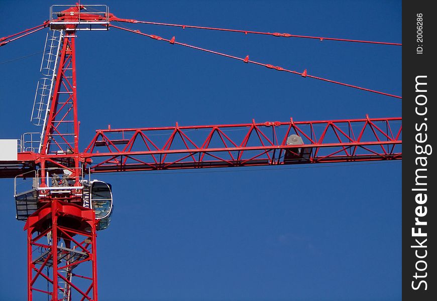 Construction Crane with focus on operator area.  Red on blue. Construction Crane with focus on operator area.  Red on blue.