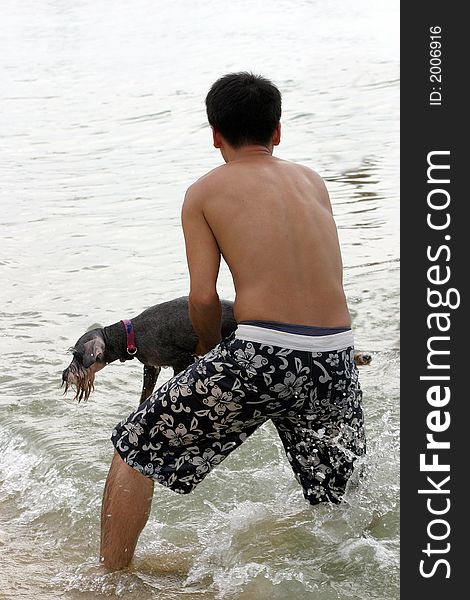 Man forcing the dog into the water. Man forcing the dog into the water