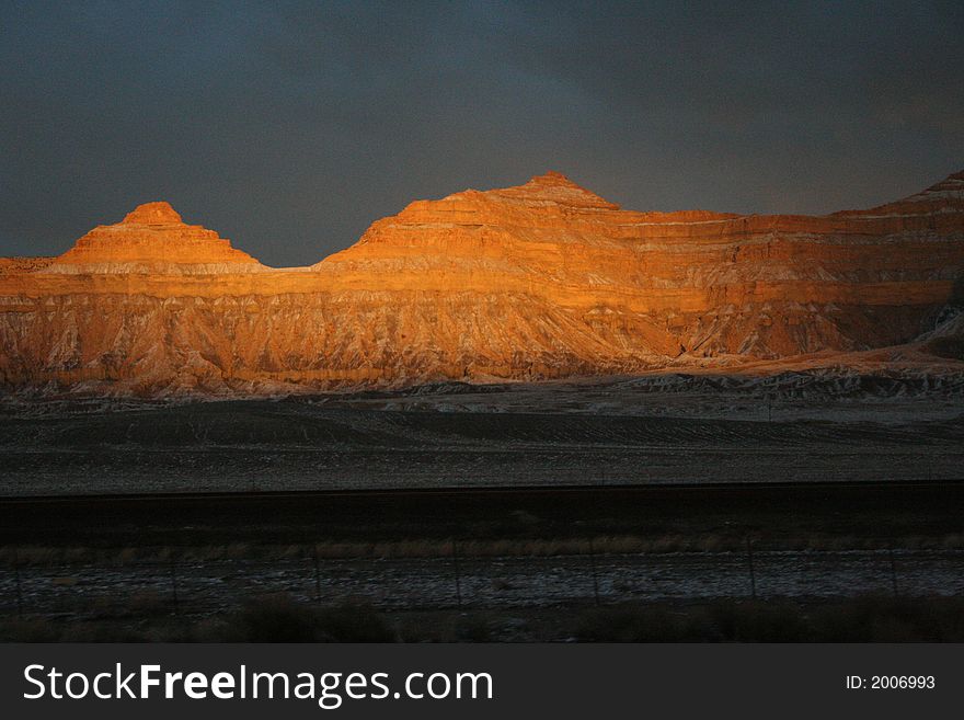 A peaceful orange sunset falls on striped cliffs in southeastern Utah. A peaceful orange sunset falls on striped cliffs in southeastern Utah.