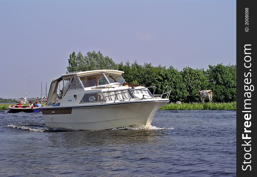 Motoryacht cruising in the countryside in Holland
