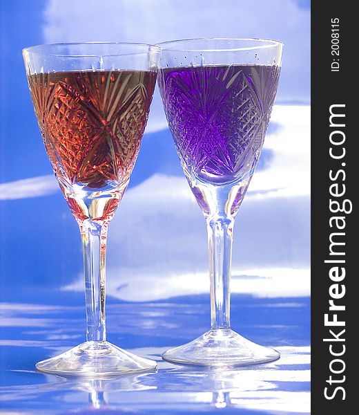 Tall glasses with red and blue  drinks on blue background. Tall glasses with red and blue  drinks on blue background