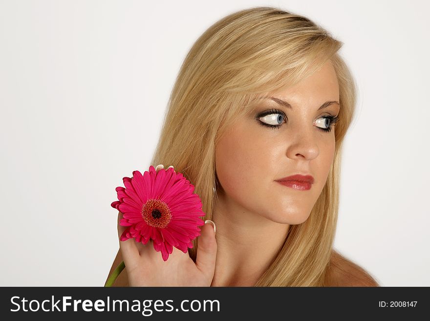 A woman holding in pink flower in her hand. A woman holding in pink flower in her hand