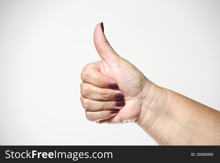 A woman's hand giving the thumbs up hand gesture.