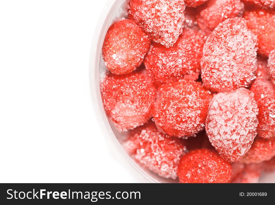 Frozen strawberries fruit in small pieces of ice and sugar. Frozen strawberries fruit in small pieces of ice and sugar