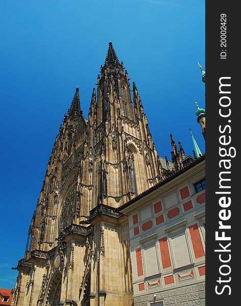 Prague gothic cathedral, by the city castle, against a blue sky. Prague gothic cathedral, by the city castle, against a blue sky.