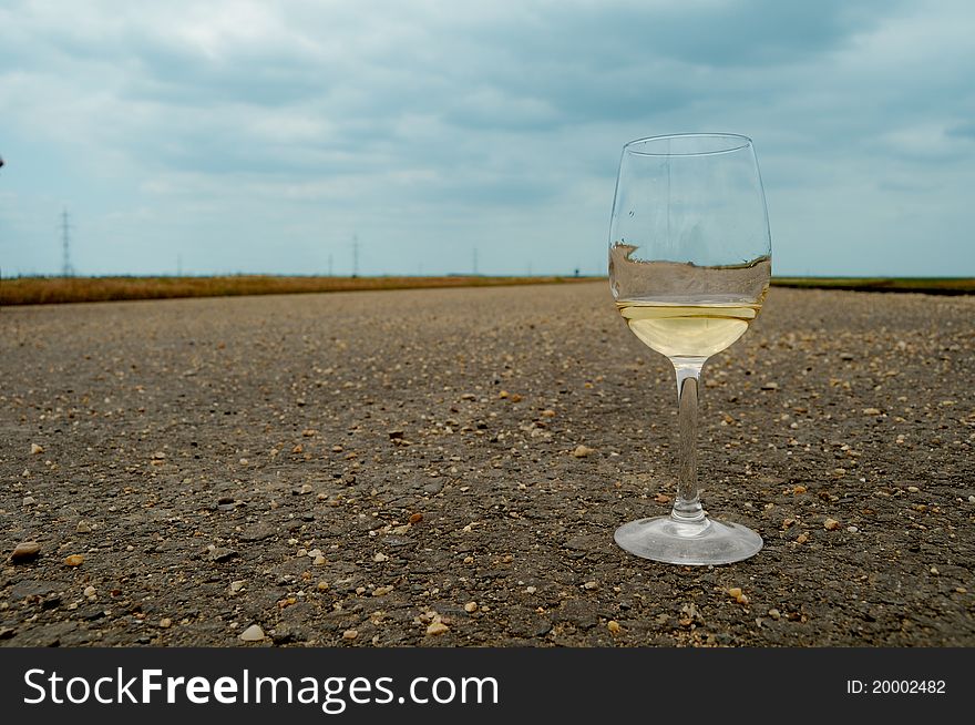 Glass of wine on the road. Concept image for drinking and driving. Glass of wine on the road. Concept image for drinking and driving