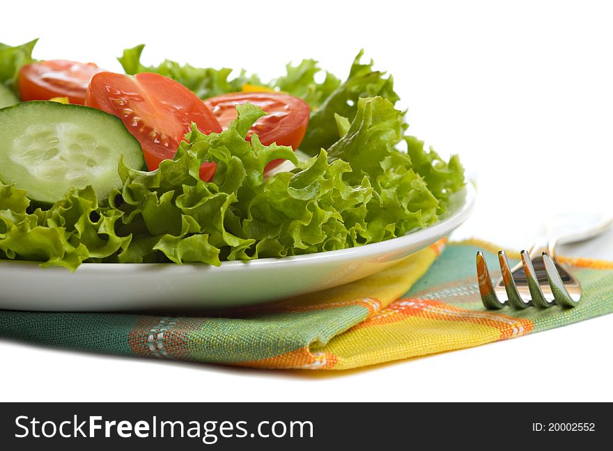 Fresh salad on white plate and a fork