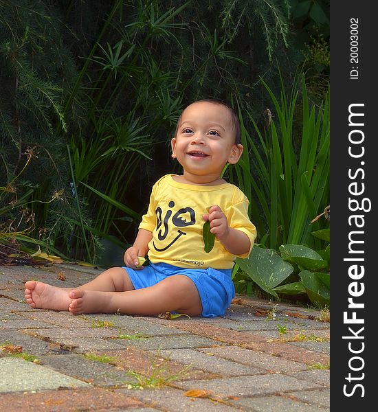 9 month old baby boy looking in wonder in a beautiful garden. 9 month old baby boy looking in wonder in a beautiful garden