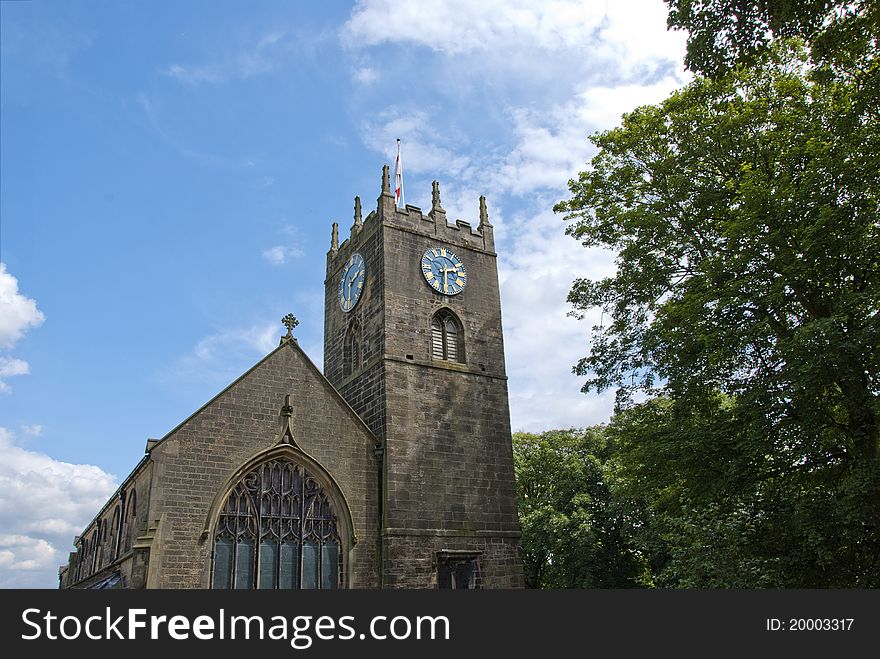 The Parish Church of St Michael and All Angels in Haworth Yorkshire under a blue summer sky. The Parish Church of St Michael and All Angels in Haworth Yorkshire under a blue summer sky