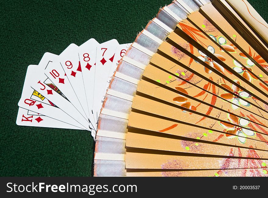 The Diamonds of the Poker playing cards put streetwise covered by a traditional Spanish wooden fan. The Diamonds of the Poker playing cards put streetwise covered by a traditional Spanish wooden fan.