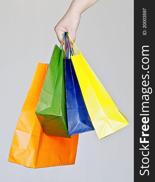 Human hand with some shopping bags with different colors