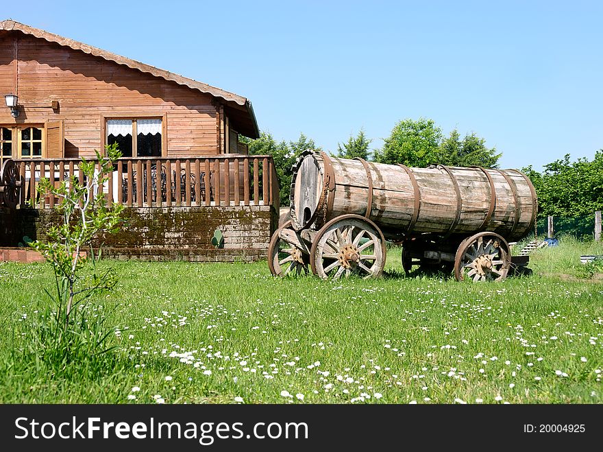 Wooden house with an old tank barrel