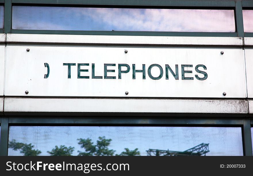 A sign indicating public telephones