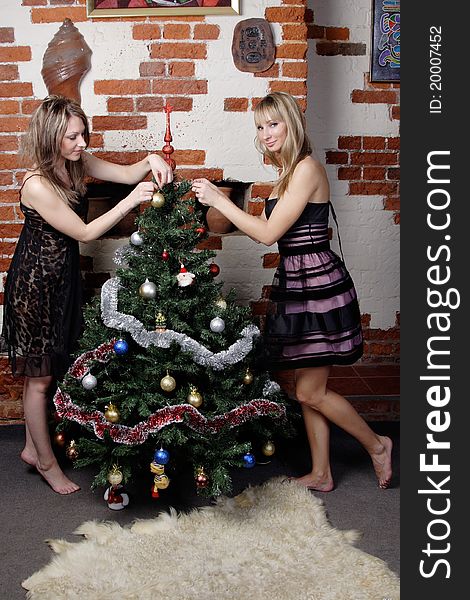 Two Young Beautiful Girls Decorate Christmas Tree