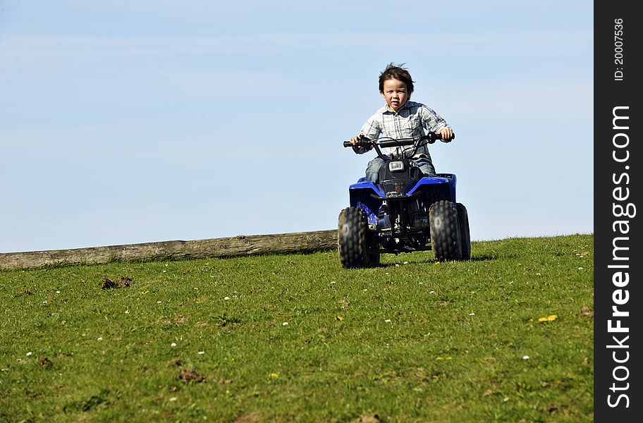 Young boy driving an ATV. Young boy driving an ATV