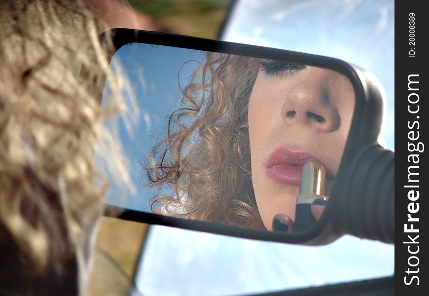 Girl with lipstick and mirror of car