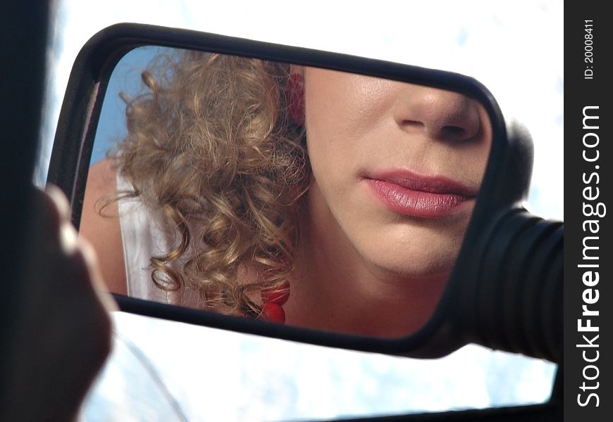 Girl with lipstick and mirror of car