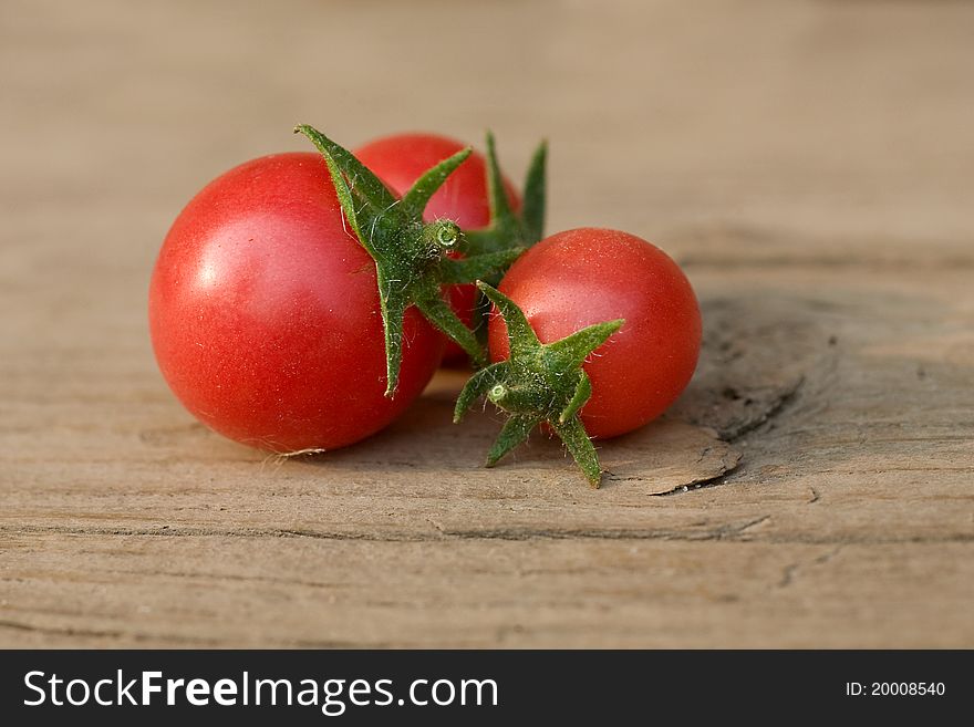 Small red cherry tomatoes on a wood table. Daily light. Small red cherry tomatoes on a wood table. Daily light