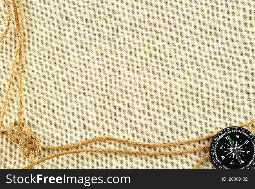 Compass and rope on with a canvas of burlap