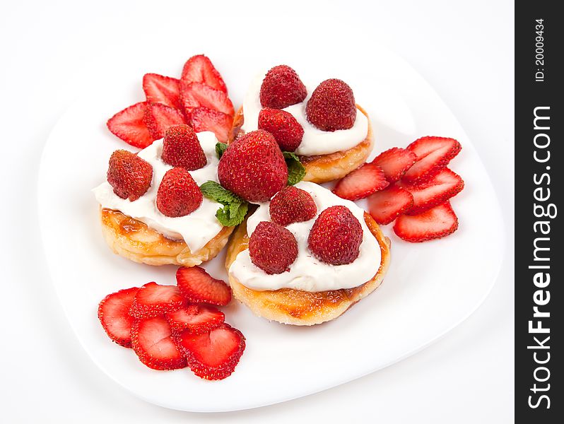 Pancakes with strawberries and cream on white plate