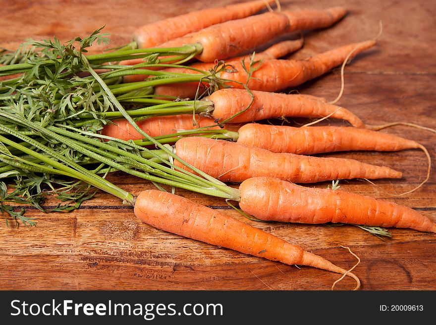 Fresh loose carrots on the wooden table. Fresh loose carrots on the wooden table.