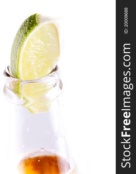 Beer bottle with lime wedge in white background