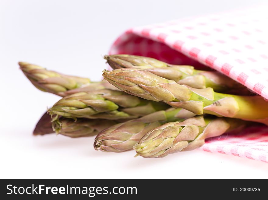 Asparagus wrapped  with pink table cloth in white background. Asparagus wrapped  with pink table cloth in white background.