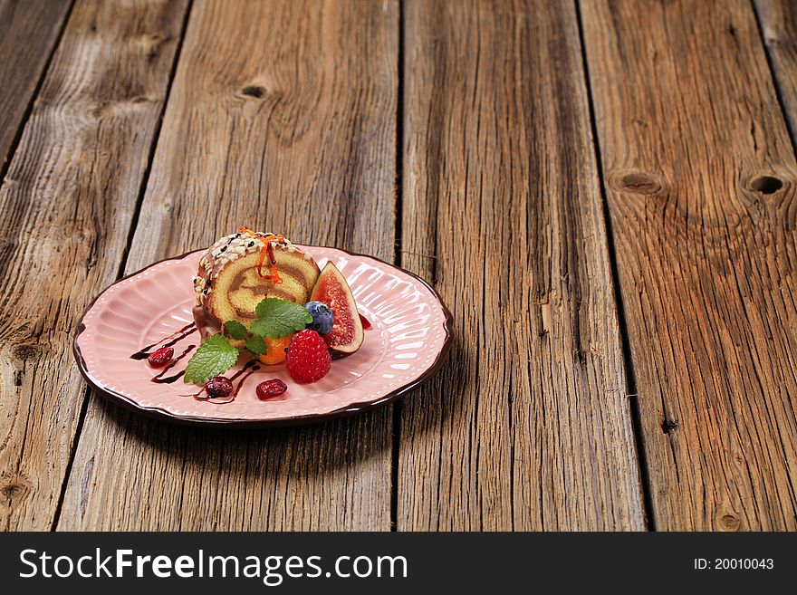 Chocolate Swiss roll garnished with fresh fruit